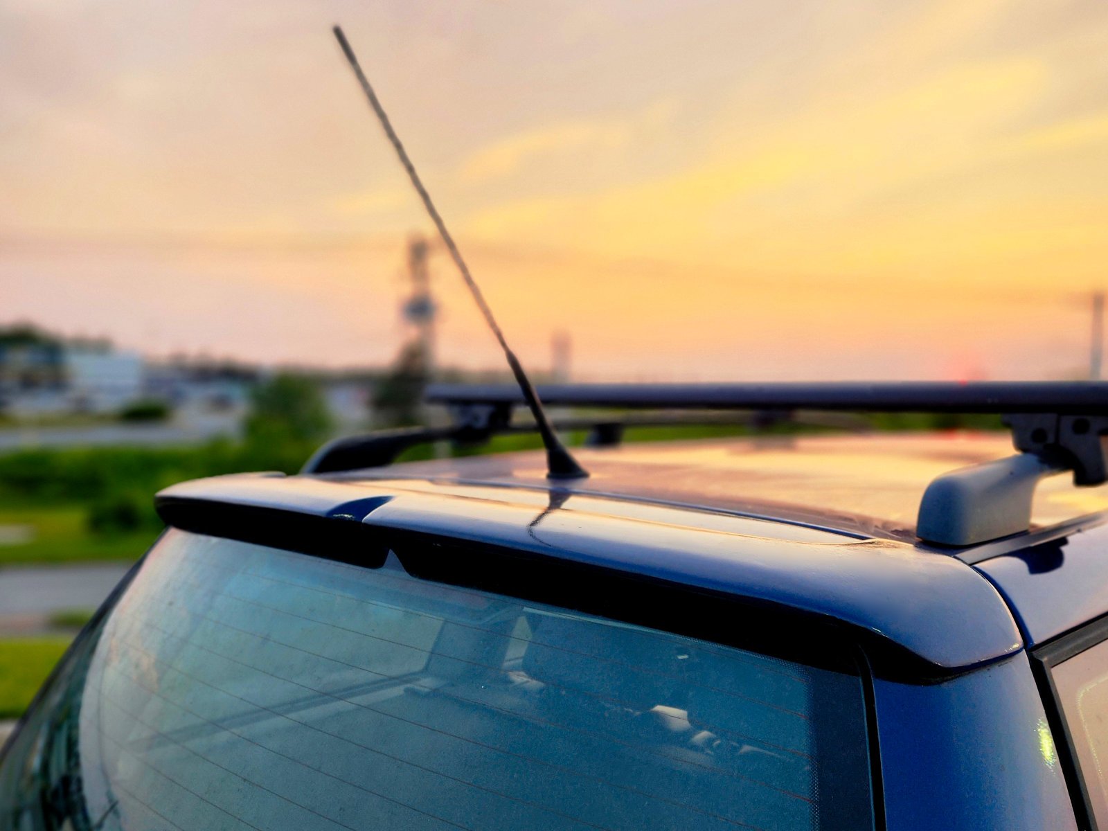 Close-up of a painted rear hatch spoiler installed on a Volkswagen MK4 wagon at sunset